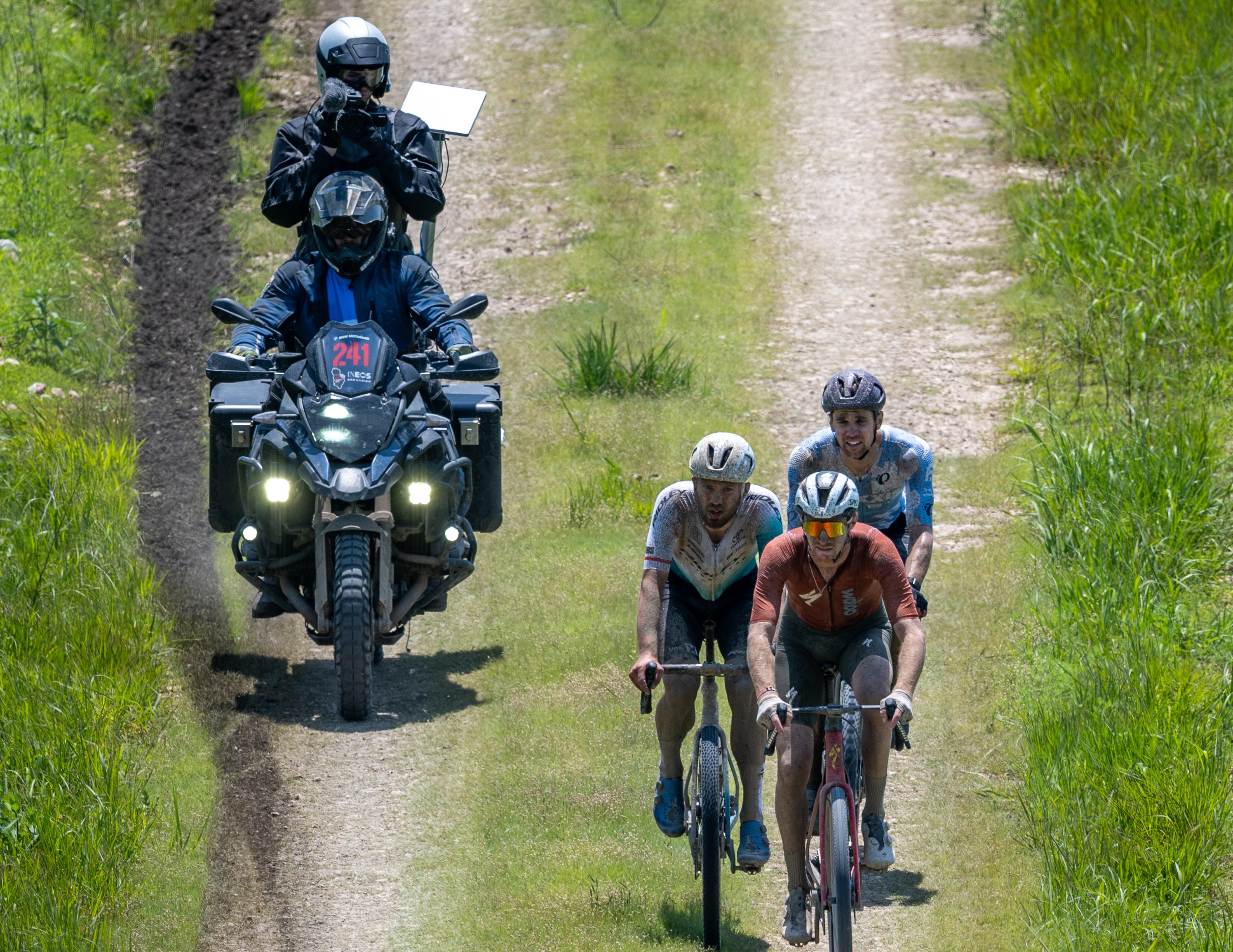 A moto with camera follows elite men at 2025 Unbound Gravel 200
