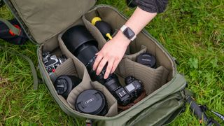 The PGYTech OnePro Focux Backpack, hand reaching into the main compartment, which is full of camera gear