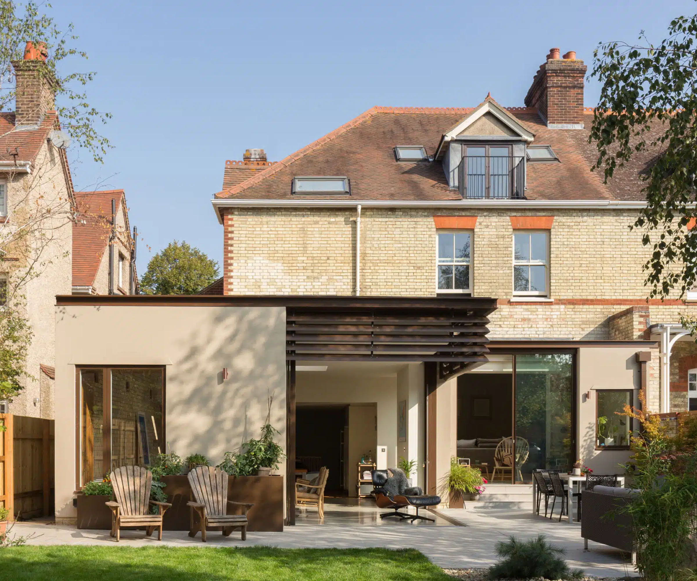 flat roof extension with rendered elevation and slatted roof detail to one side with corner glazing below