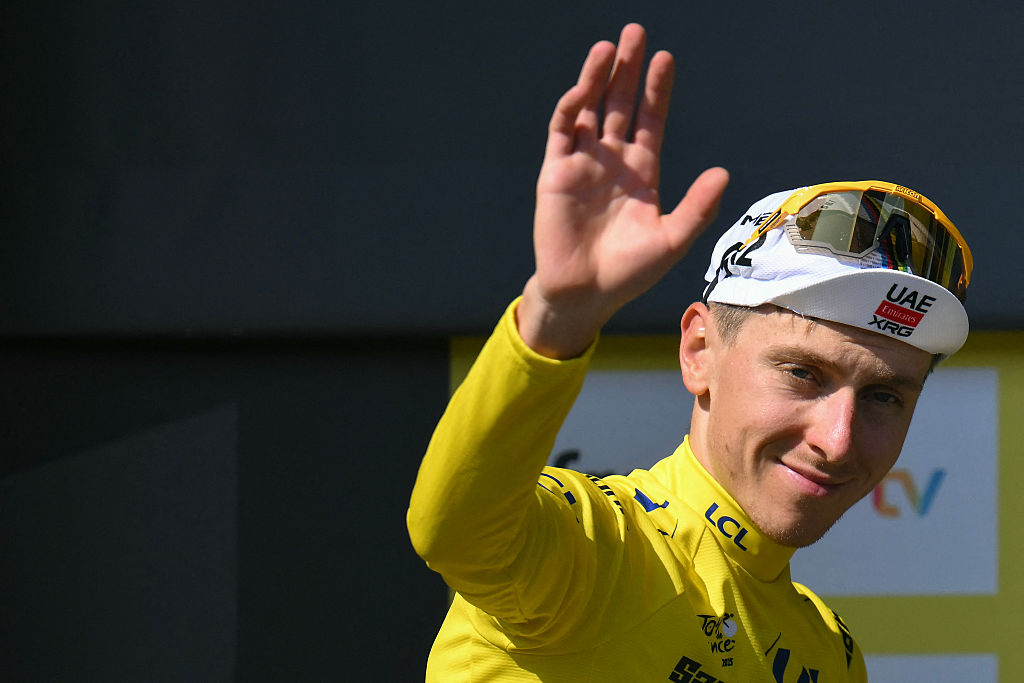 UAE Team Emirates - XRG team's Slovenian rider Tadej Pogacar celebrates on the podium with the overall leader's yellow jersey after the 9th stage of the 112th edition of the Tour de France cycling race, 174.1 km between Chinon and Chateauroux, central France, on July 13, 2025. (Photo by Marco BERTORELLO / AFP) (Photo by MARCO BERTORELLO/AFP via Getty Images)