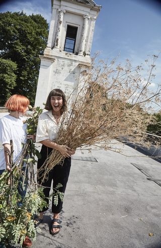 two people with flowers leaving building