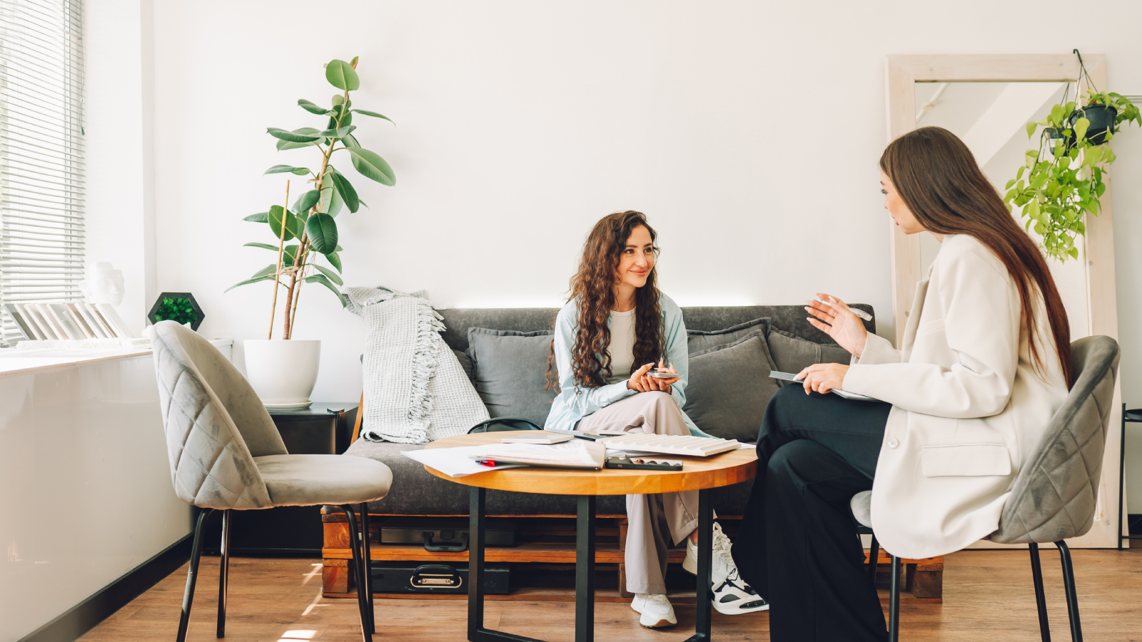 two females sat in living room talking 