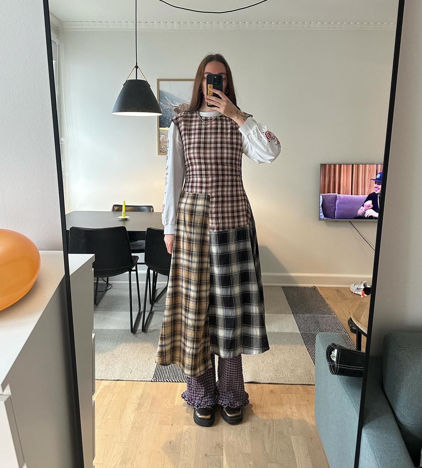 woman wearing a checked dress over trousers