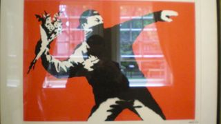 Banksy artwork of man throwing flowers