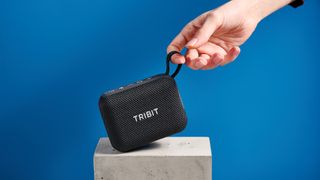The Tribit PocketGo speaker in black photographed on a blue background.