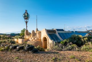 Earthship community in Taos showing colourful off grid homes nestled into the desert earth