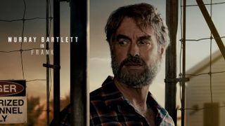 The LAst Of Us cast poster featuring Frank (Murray Bartlett) standing next to a chainlink fence.