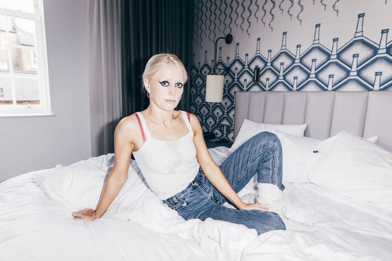 Members of Amyl and the sniffers sat on a bed