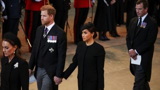 Prince Harry, Duke of Sussex and Meghan, Duchess of Sussex and Peter Phillips arrive in the Palace of Westminster after the procession for the Lying-in State of Queen Elizabeth II on September 14, 2022 in London, England.
