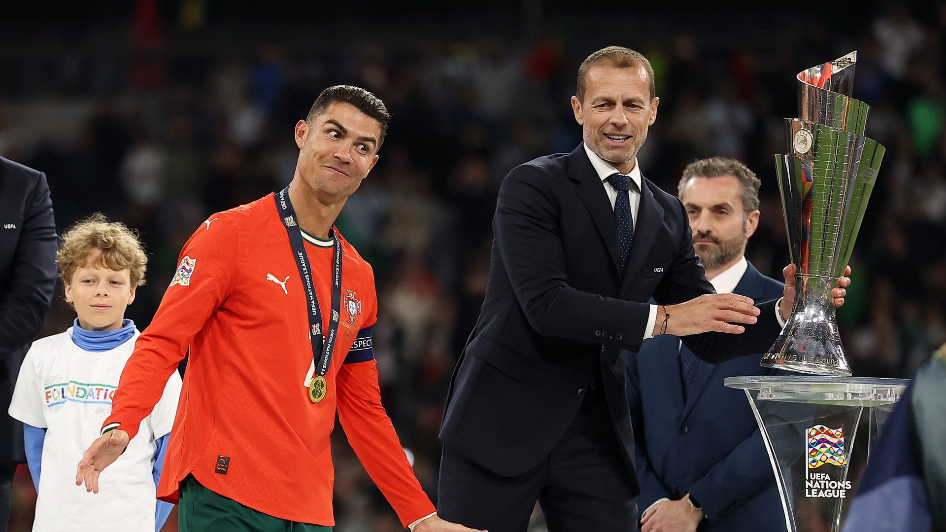 Cristiano Ronaldo of Portugal reacts, as Aleksander Ceferin, President of UEFA, prepares to present him with the UEFA Nations League trophy