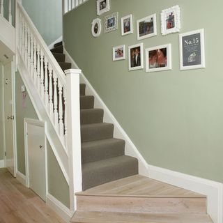 hallway with stairway and photo frames on wall