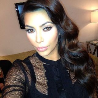 Kim Kardashian with wavy hair swept to the side.