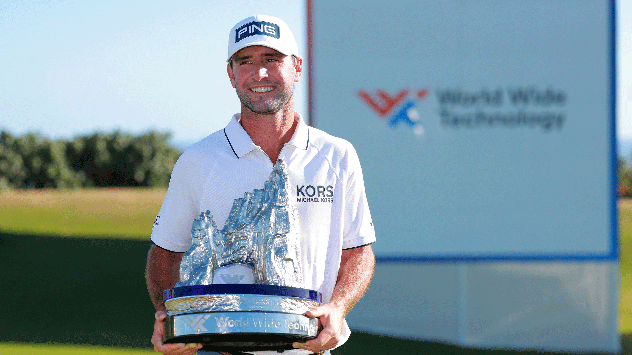 Austin Eckroat poses with the World Wide Technology Championship trophy in 2024