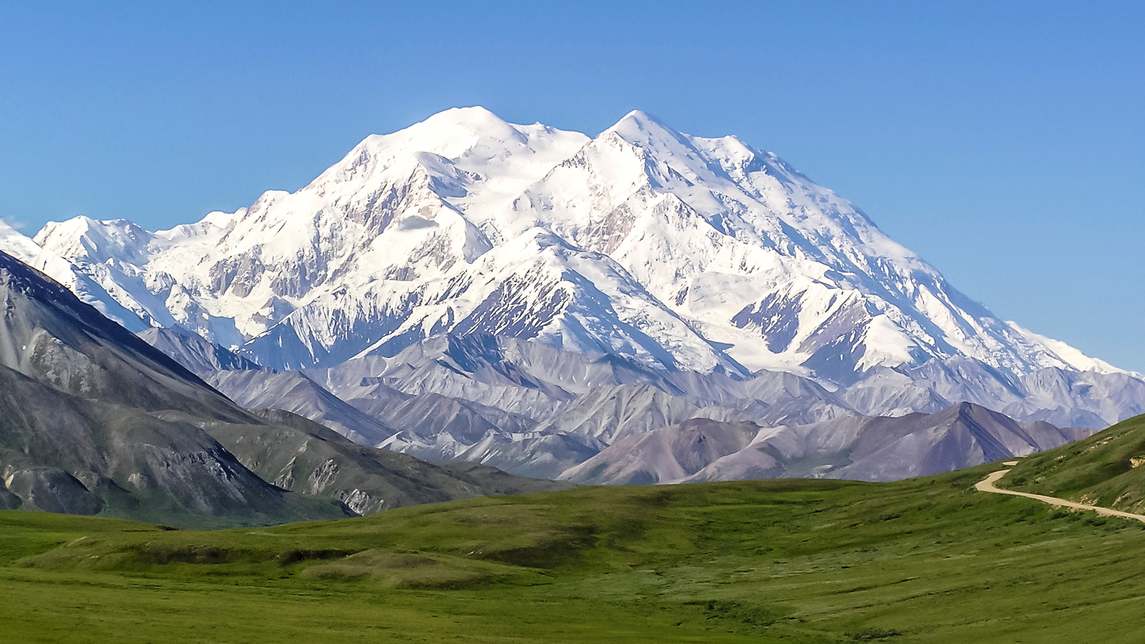 Mount Denali on a clear day with blue sky and snow covered peaks