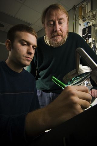 Richard Lenski oversees the count of micorganisms growing in a Petri dish used in a study of evolution.