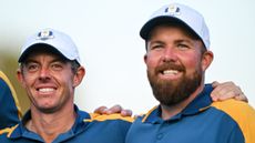 Rory McIlroy and Shane Lowry smile while arm in arm at the 2023 Ryder Cup