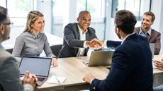 Happy businessmen shaking hands at a meeting in the office.