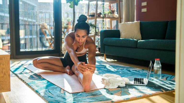 Woman practices yoga in a bright apartment space