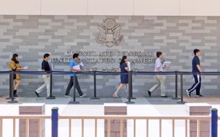 People standing in a queue in front of the U.S. consulate in Guangzhou, China.