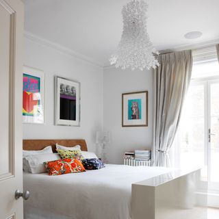 white bedroom with bed and walled pictures