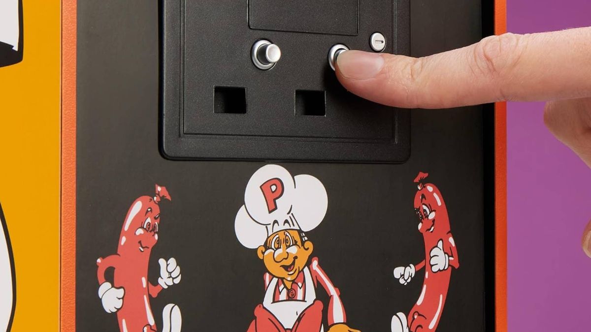 Close up of finger pressing Quarter Arcades Burger Time coin button