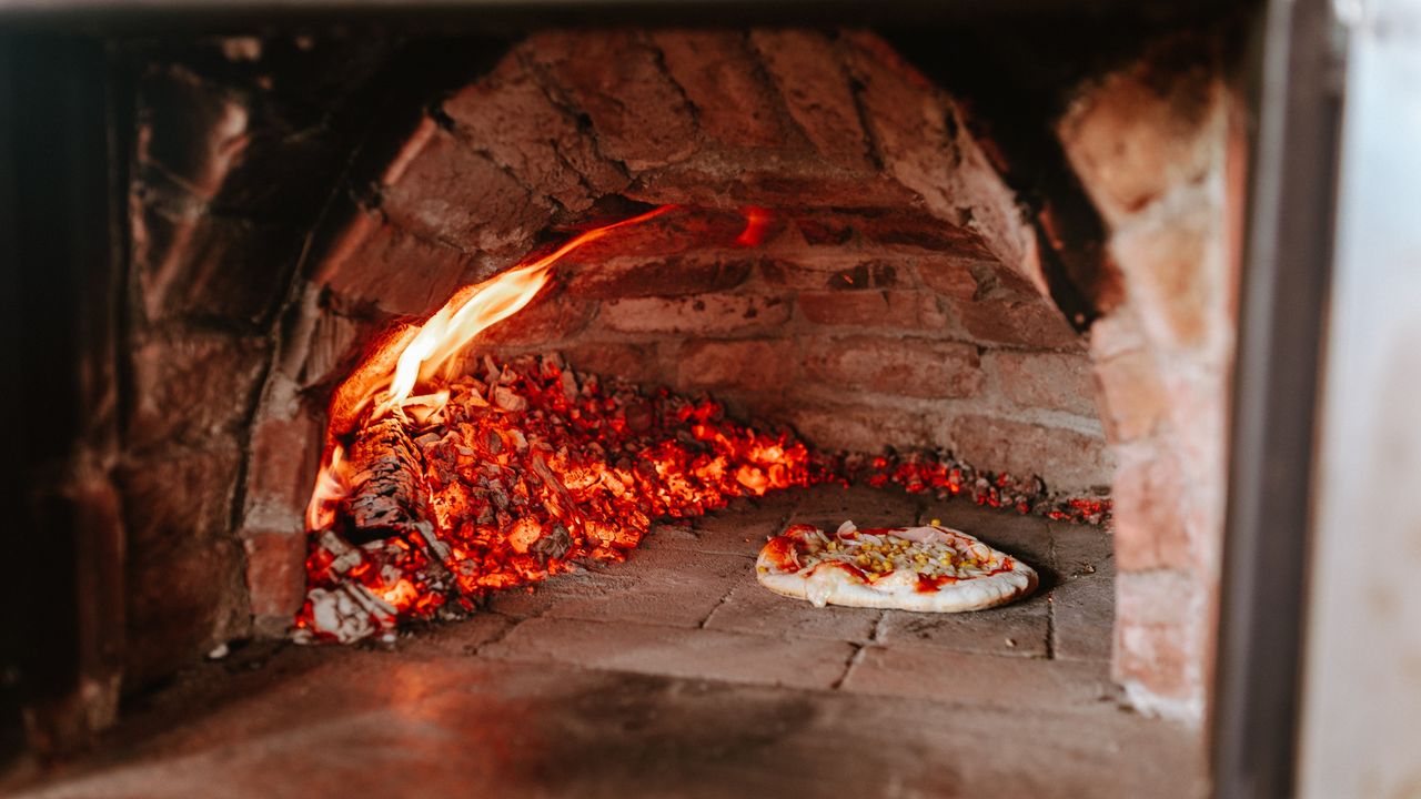 Pizza cooking in traditional wood-fired oven