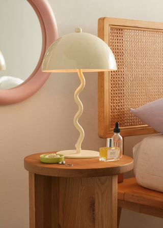 white table lamp with a wiggle base on a bedside table