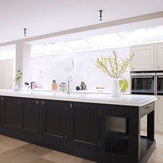 kitchen with white wall and glass roof with black cabinets