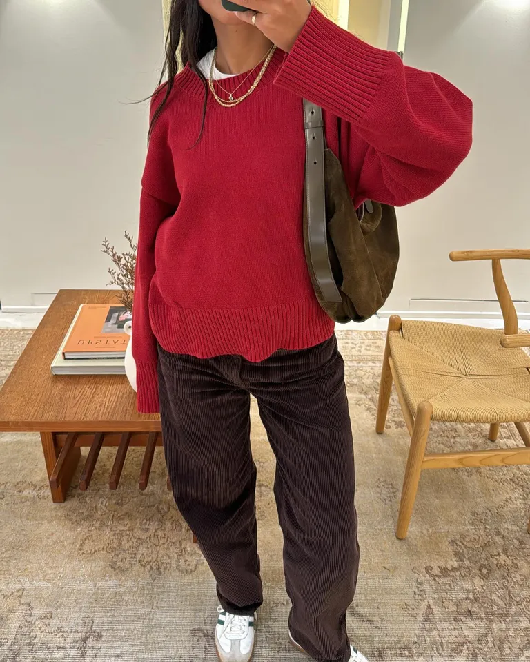 Woman in red sweater and corduroy pants