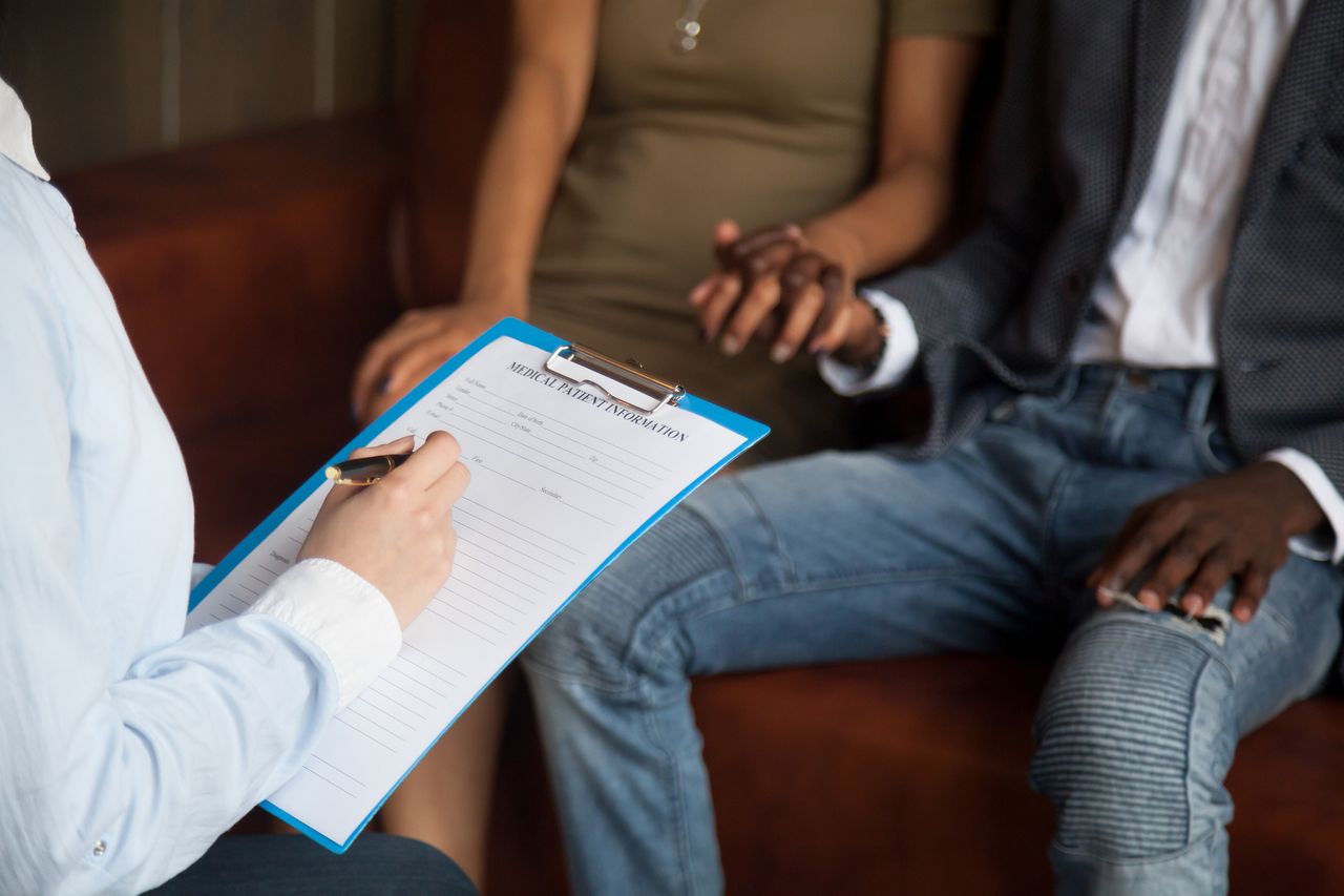 Statutory time off for IVF: A couple hold hands in front of a doctor