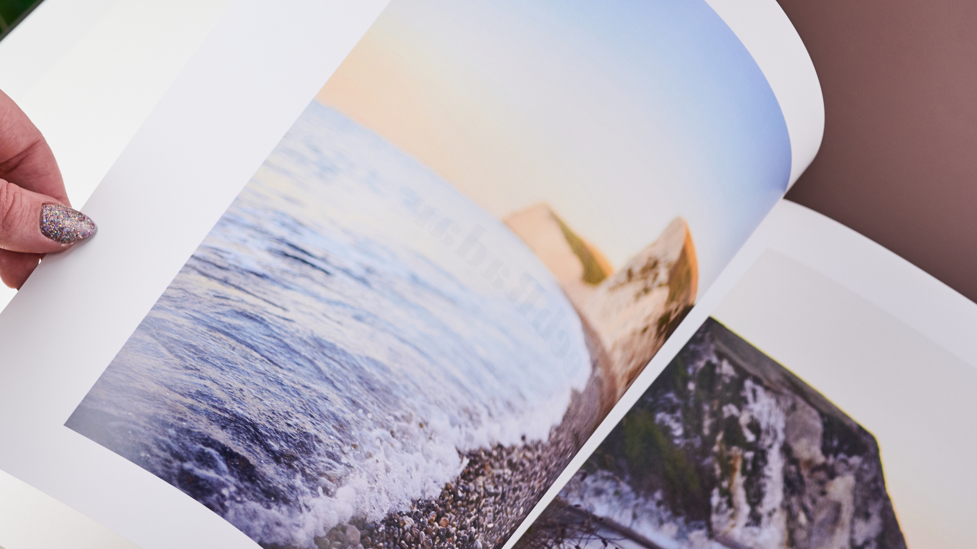 A woman is turning a page of the Once Upon photo book.