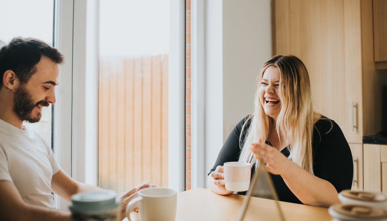 couple laughing and drinking coffee