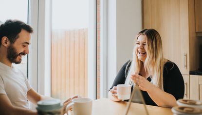 couple laughing and drinking coffee