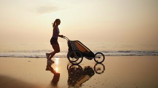 Woman with running stroller on beach