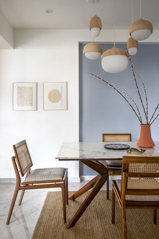 A dining room with an accent wall painted blue
