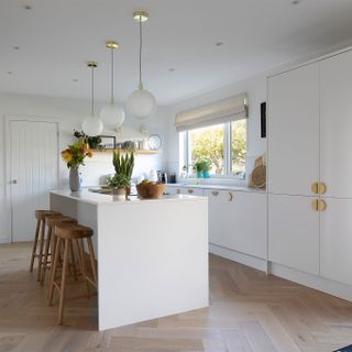 white kitchen with island and wooden bar stools