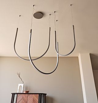 U shaped pendant light hanging from a white ceiling