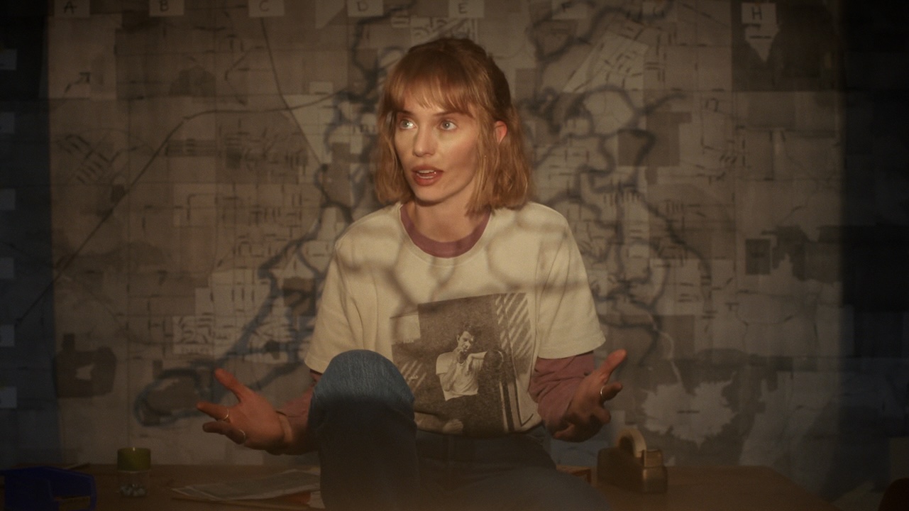 Robin describing The Great Escape in front of a map in Stranger Things