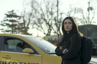 luciane buchanan as rose larkin standing by a taxi cab in a still from the night agent season 2