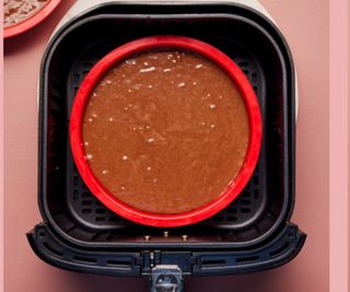Cake batter in a silicone tin inside an air fryer drawer