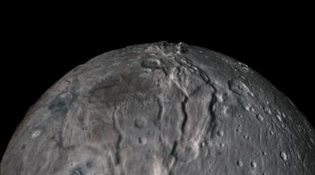 A black and white image of a body in space with craters and cracks.