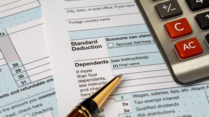 Standard deduction on federal income tax return forms, calculator and pen