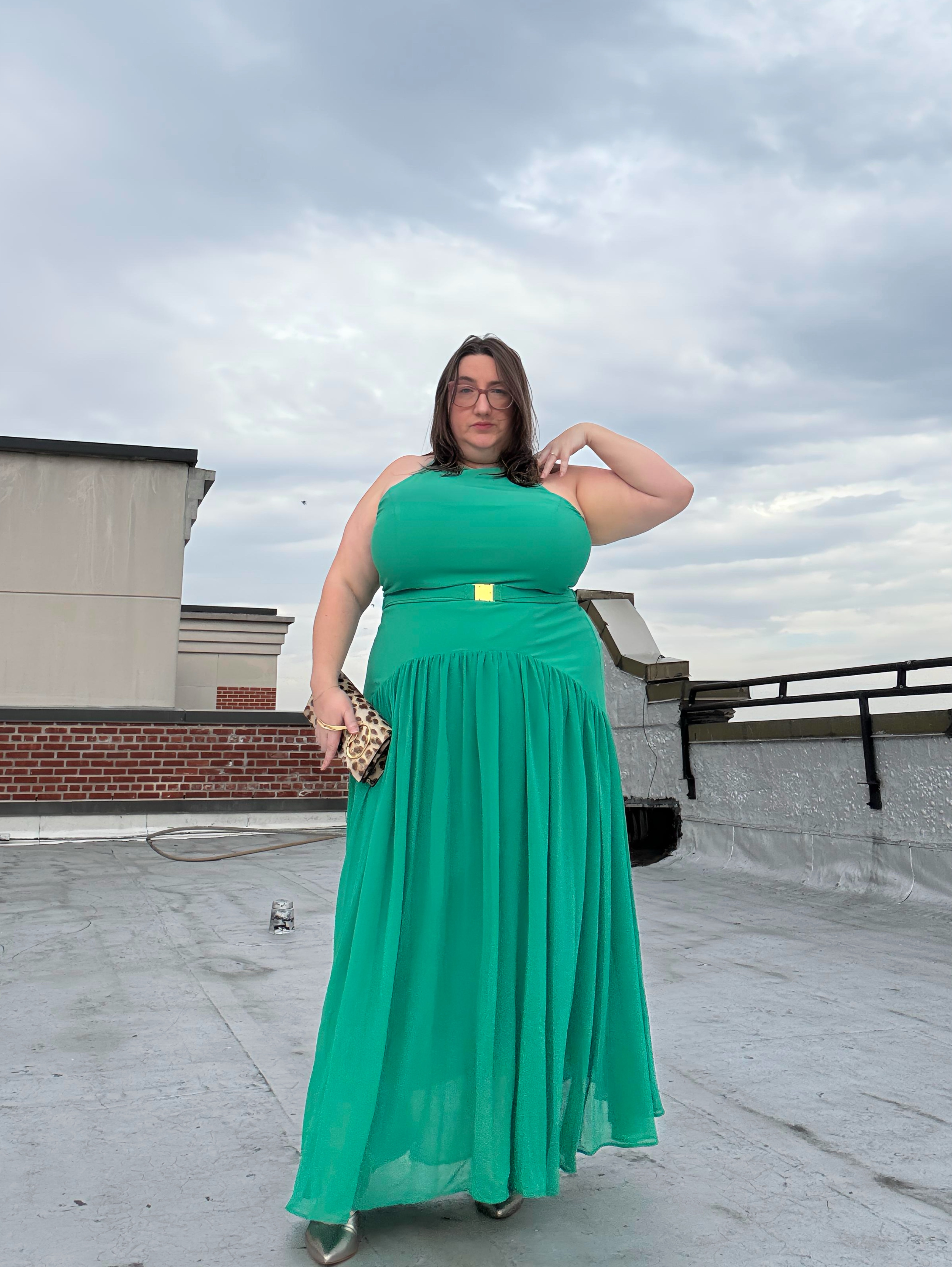 Sarah Chiwaya wears a drop-waist maxi dress in mint green with an animal print clutch