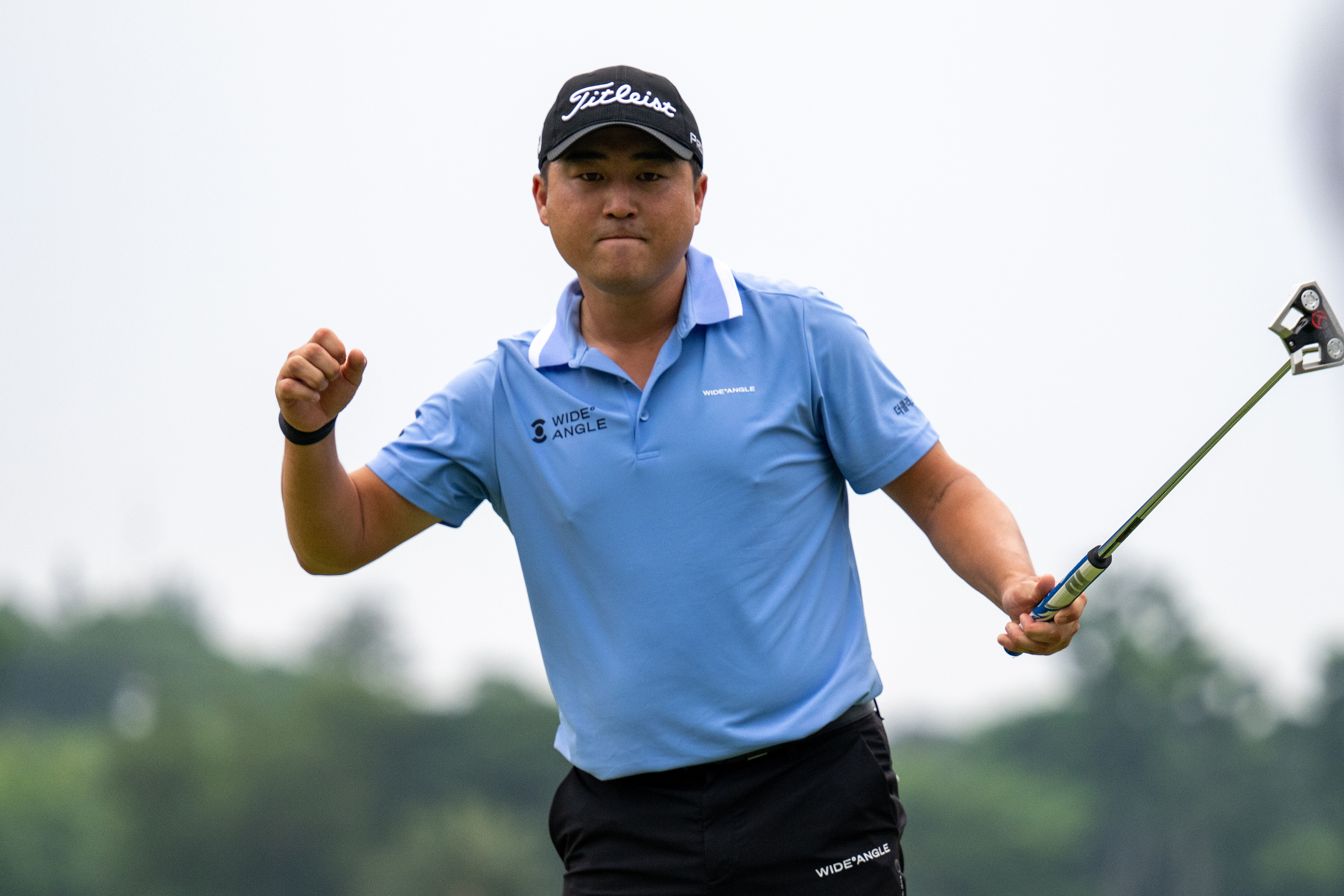 Richard T Lee holds his putter in the air