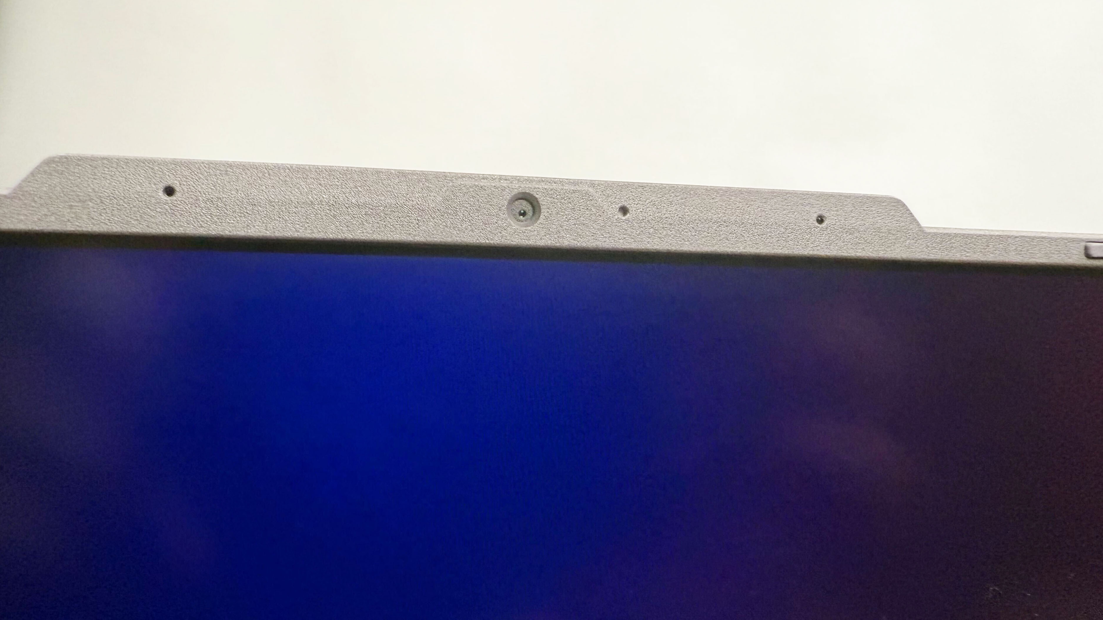 Close up of the webcam on the Asus ROG Strix G16 (G614FR) gaming laptop against a gray background.