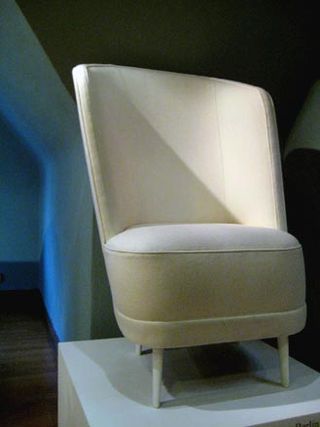 Palm- shaped cream single sofa on display and photographed on a white platform