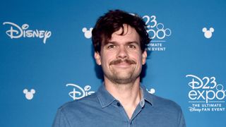 Michael Waldron smiles as he poses for photographs at D23 Expo