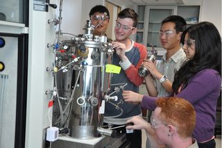 Students help set up the Mango Materials bio-reactor for producing "green" plastics.