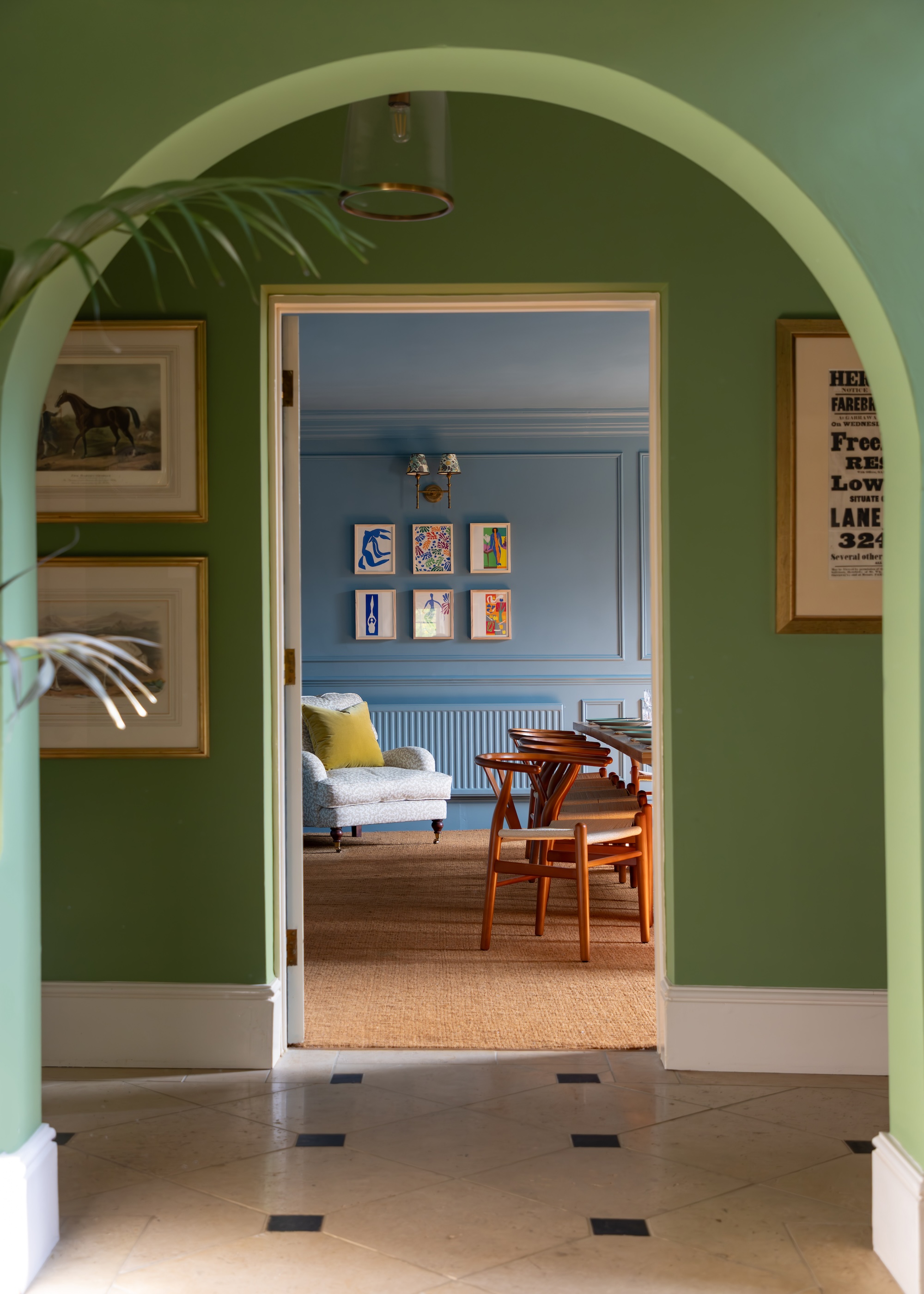 a bold colored interior showing green wall paint in the hallway leading into a pale blue paint in the adjoining room