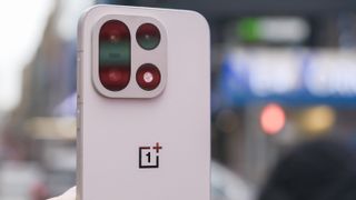 OnePlus 15 in Times Square New York City on the busy street showing the cameras and sides of the phone in addition to home screen panels and Settings menus